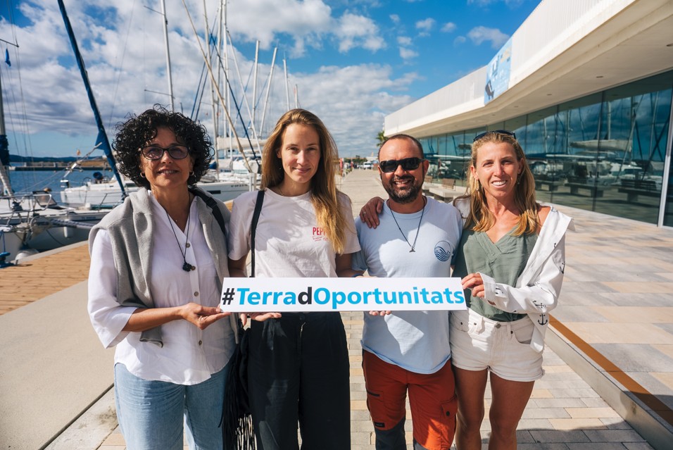 Representants dels quatre projectes reconeguts pel Terra d'Oportunitats es fan una foto al costat de l'Espai Medes amb un cartell amb el nom del programa
